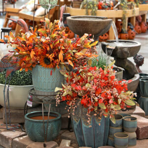 Fall garden display with autumn floral arrangements pottery a tiered fountain lanterns and pumpkin décor